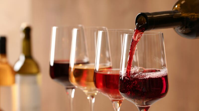 Glasses of red, rosé, amber and white wine being poured